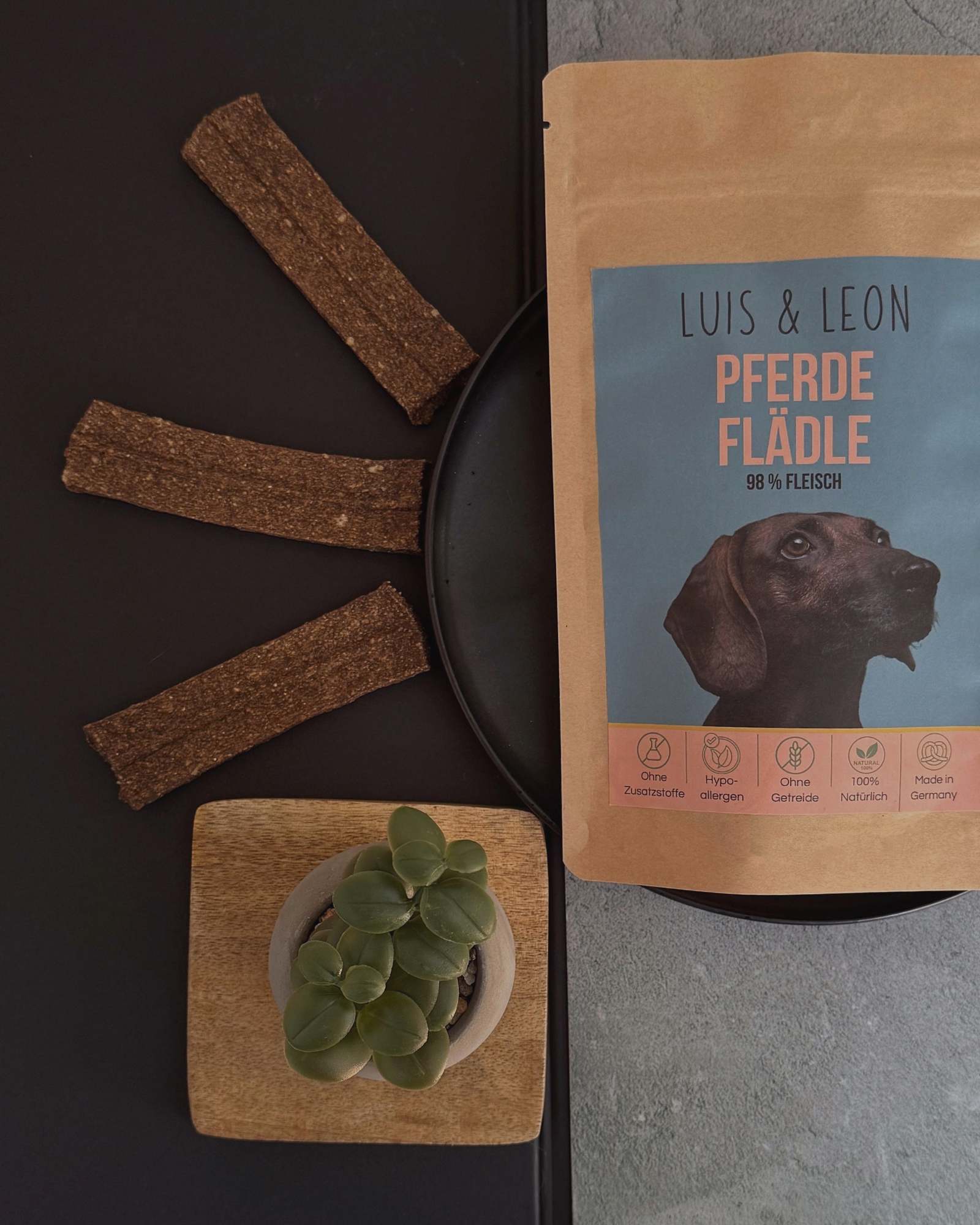 zwei Hunde sitzen vor Leckerli Beuteln